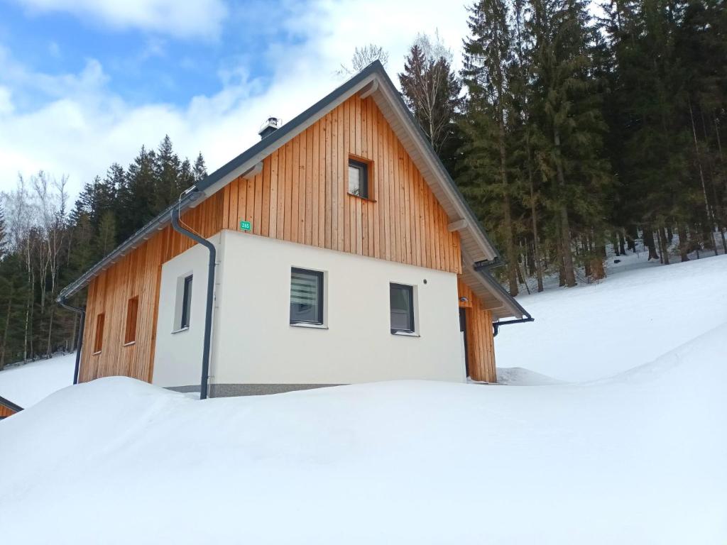 a building in the snow with trees in the background at Chalet Pod lesem by Interhome in Smržovka