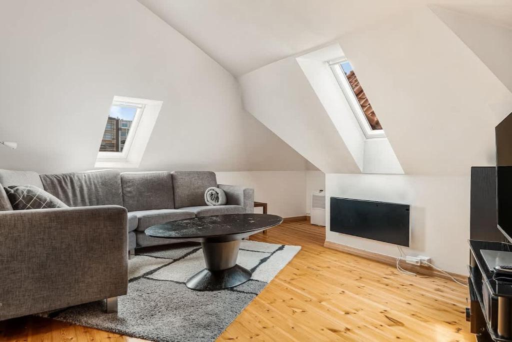 a living room with a couch and a tv at Dinbnb Apartments I Historical Two-Floor Apartment with Rooftop Panorama I 1645 Heritage in Bergen
