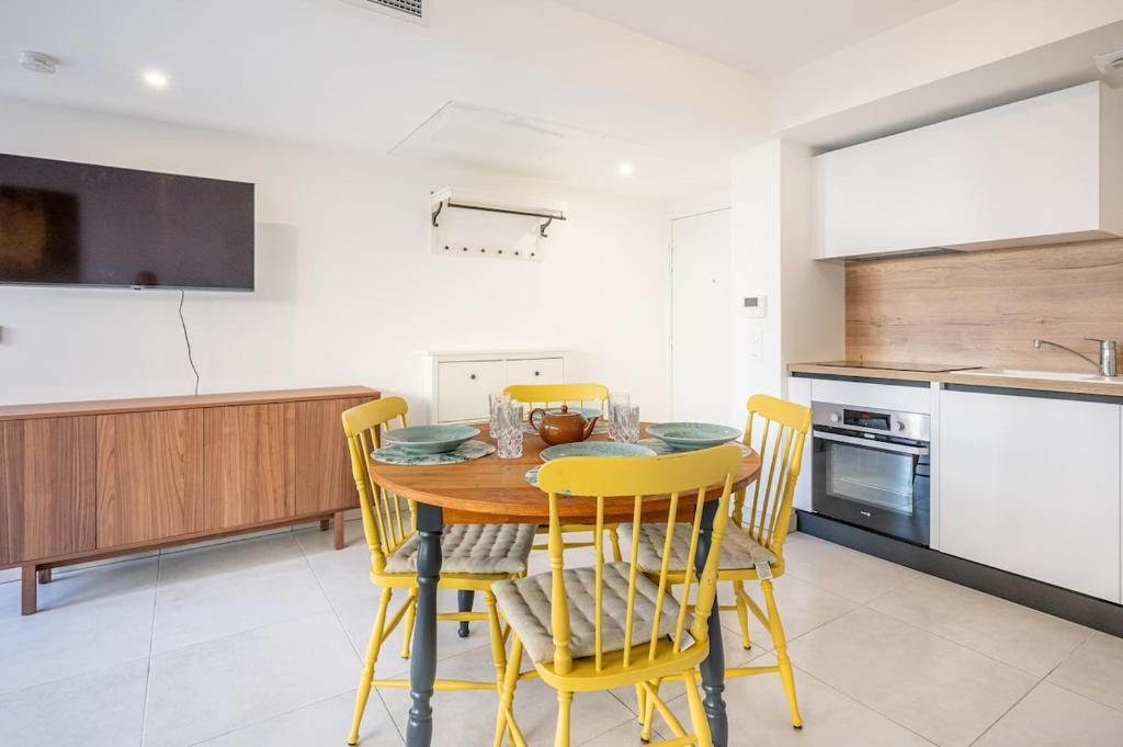 une cuisine avec une table en bois et des chaises jaunes dans l'établissement Via Marenda - Antibes Old Town Top Location and Free Parking, à Antibes
