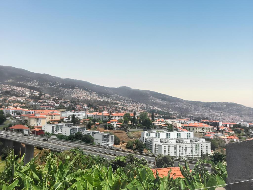 a view of a city with a highway and buildings at Charming House in Funchal with Sea View in Funchal