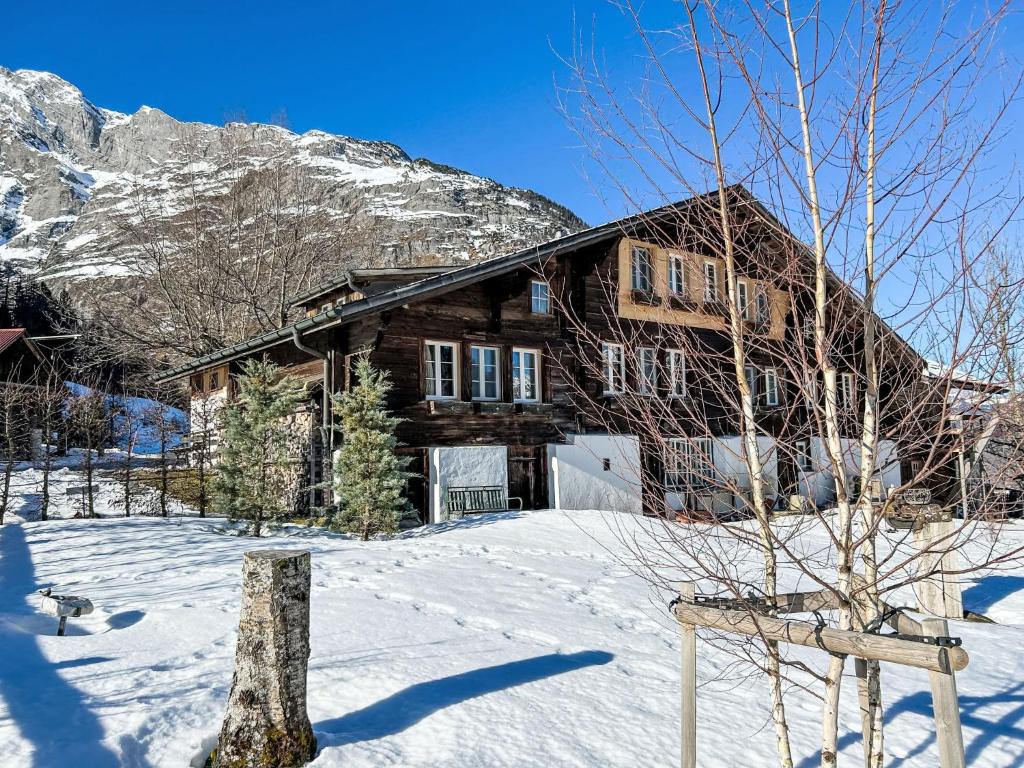 een blokhut in de sneeuw met een berg bij Apartment Chalet Solegg by Interhome in Innertkirchen