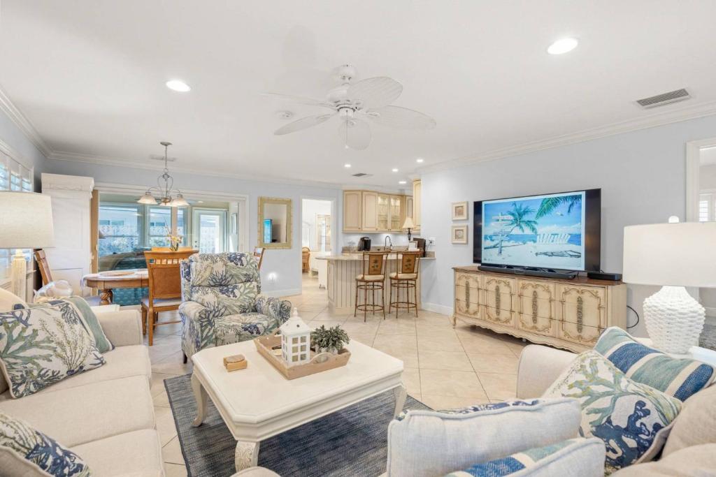 een woonkamer met een bank en een tv bij Siesta Villa Whispering Palms in Siesta Key