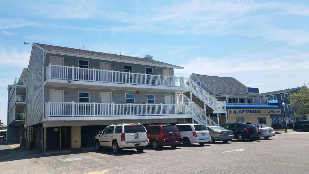 ein Gebäude mit auf einem Parkplatz geparkten Autos in der Unterkunft Atlantic Breeze Motel &amp; Apartments in Ocean City