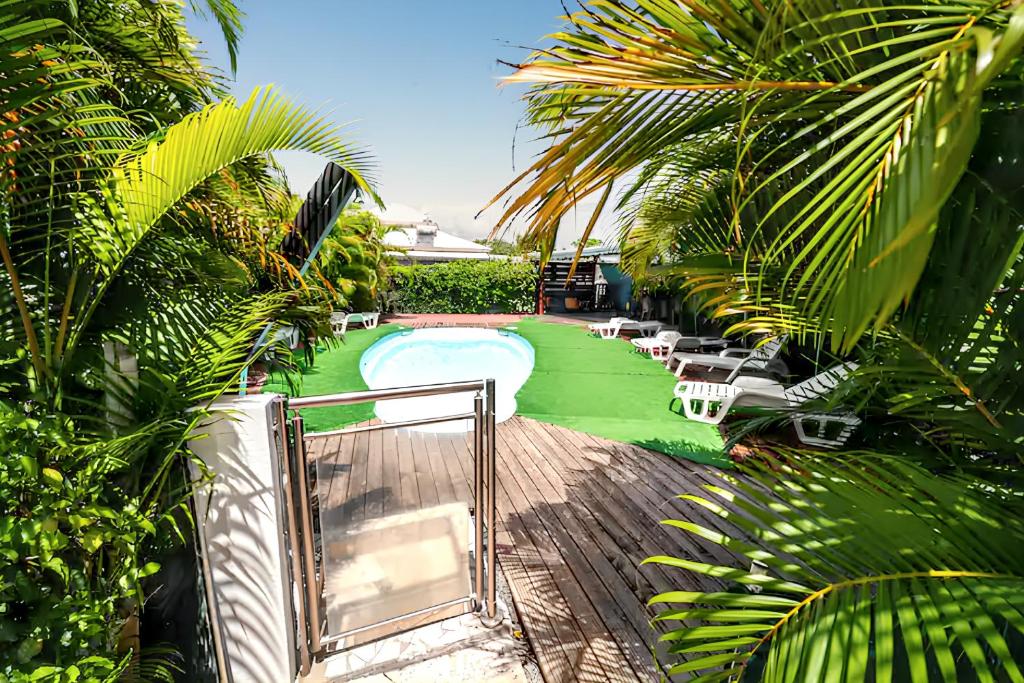 Vue aérienne d'une piscine avec un jardin verdoyant dans l'établissement Maison charmante à Sainte-Anne avec piscine partagée., à Sainte-Anne