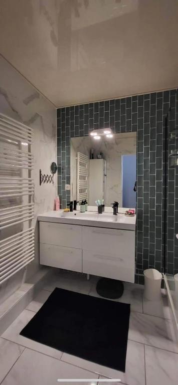 une salle de bain avec un lavabo blanc et un miroir dans l'établissement Chez Val et Paul, à Vannes