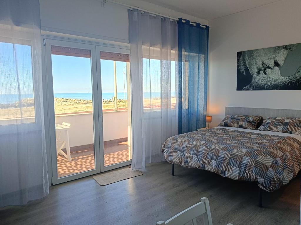 a bedroom with a bed and a view of the ocean at Mare e Relax 1 Melody Sea Front 10' da FCO Airport in Fiumicino