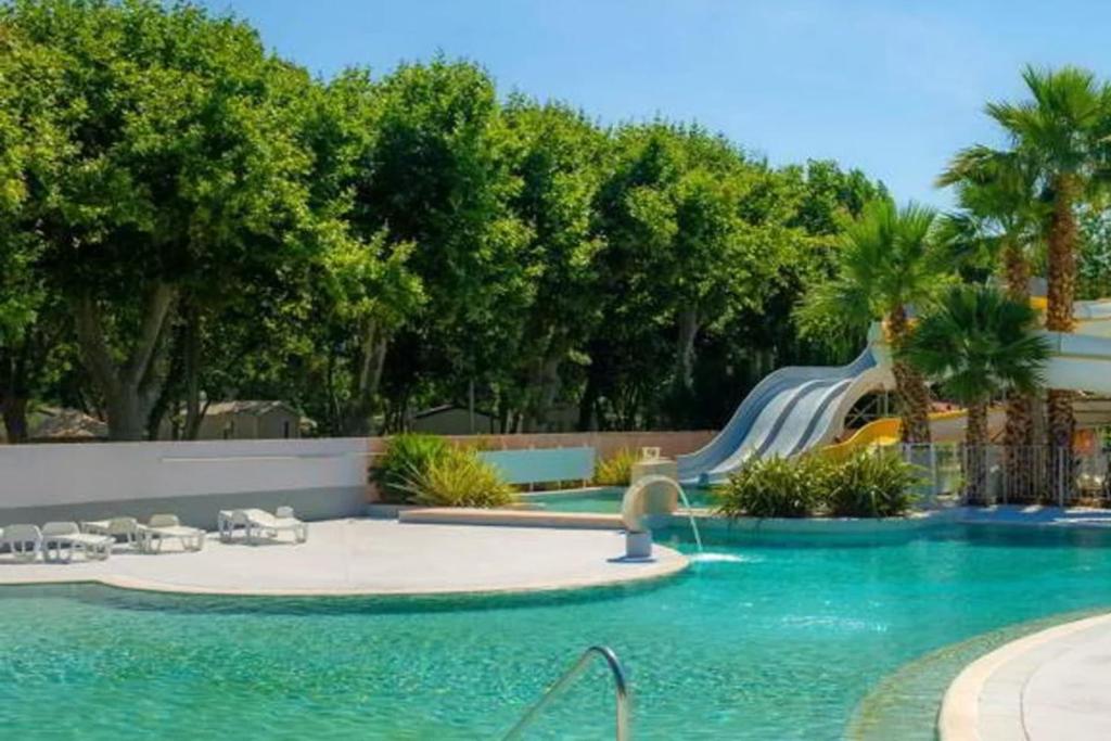 - une piscine avec toboggan dans un complexe dans l'établissement Mobile Home Camping Parc des Sept Fonts B255, à Agde