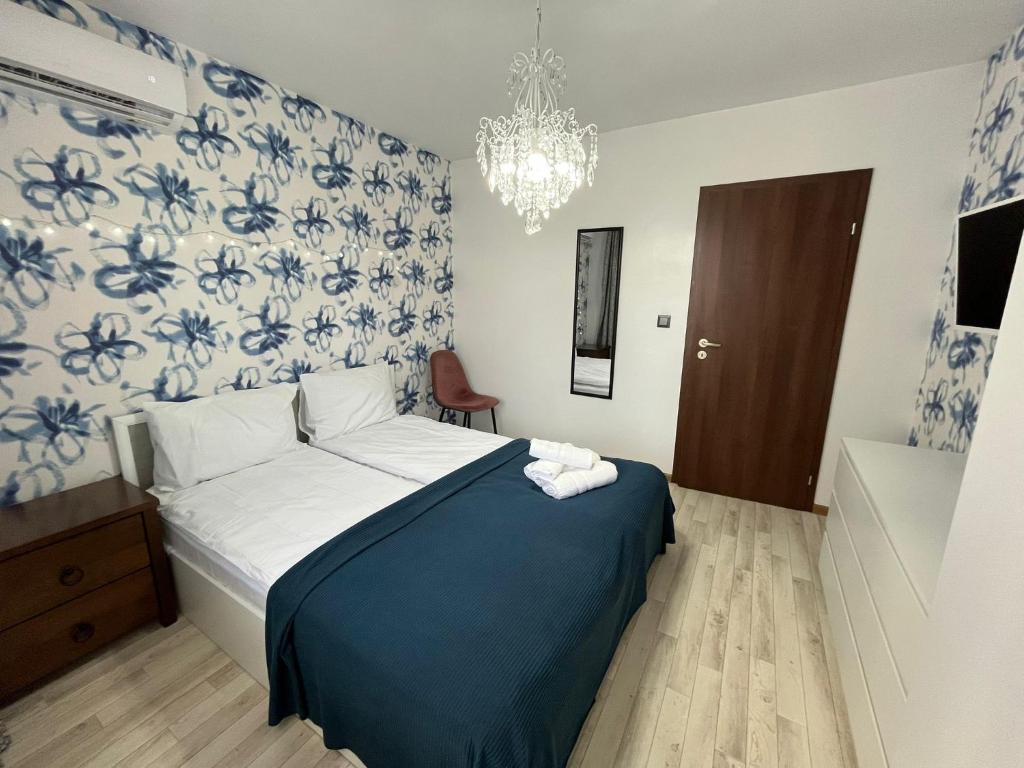 Un dormitorio con una cama con papel pintado azul y blanco. en Snowflake in Royal Park, Shuttle, SPA, en Bansko