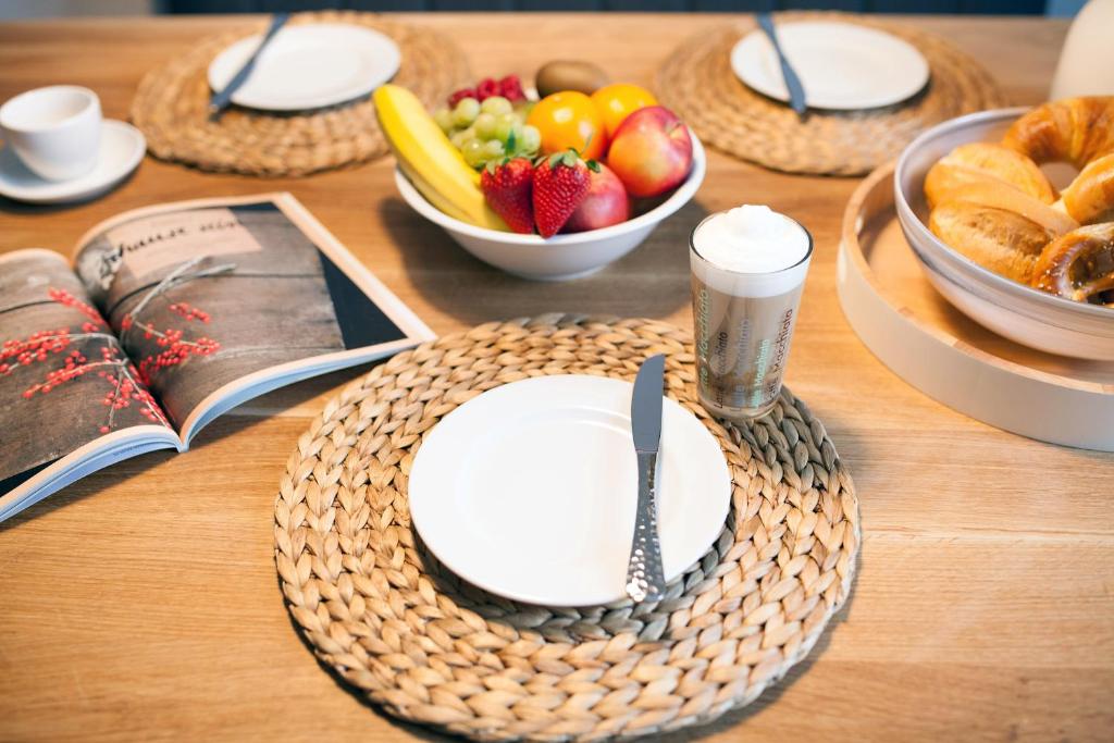 einen Tisch mit einem Teller Essen und einer Schale Obst in der Unterkunft DesignLodge Apartments in Bad Sobernheim