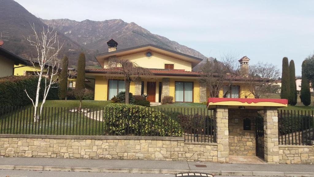 una casa amarilla con una valla delante de ella en Silvy en Endine Gaiano