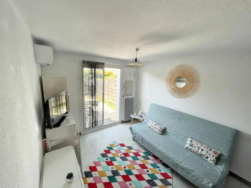 un salon avec un canapé bleu et une télévision dans l'établissement Maison cosy à La Londe-les-Maures, proche plage, à La Londe-les-Maures