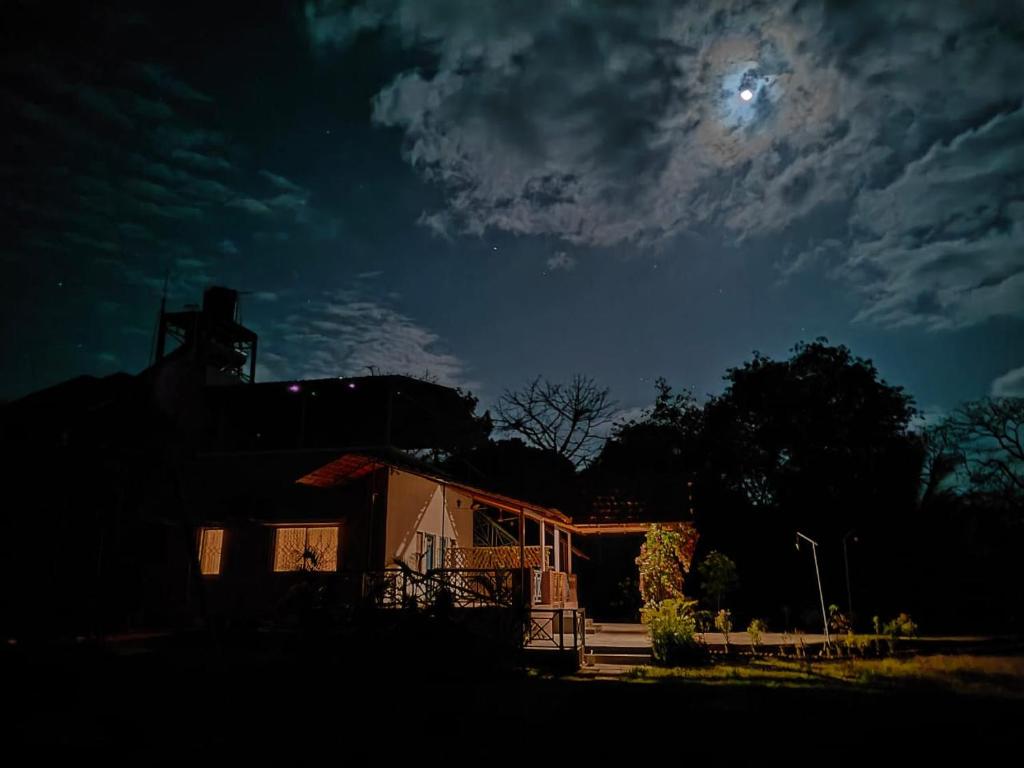 a house at night with the moon in the sky at Paradise Farm Alibaug in Bhāweghar