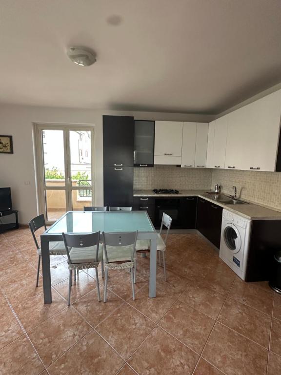 a kitchen with a table and chairs in a room at Le Piante - Appartamento in residence con piscina in Gioiosa Ionica