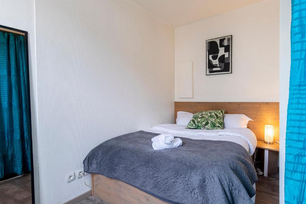 une chambre avec un lit avec une serviette dessus dans l'établissement Mini Mosaïque Parking Un Séjour à Part, à Longeville-lès-Metz