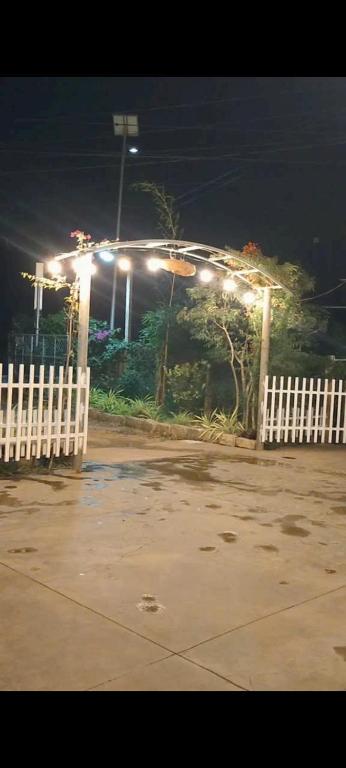 a white fence with lights in a park at night at Homestay Vạn Hưng in Vạn Ninh