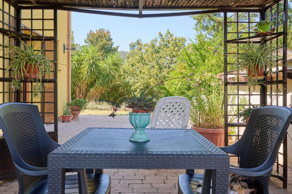 a table with chairs and a vase on a patio at Monolocale di Meo in Suvereto