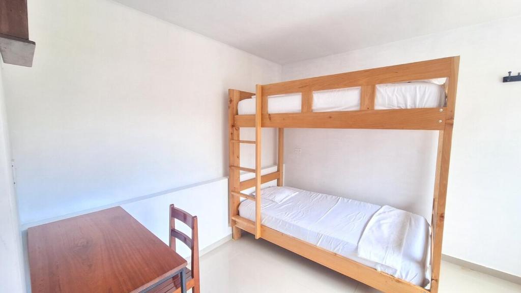 una habitación con dos literas y una mesa en Casa Qiru tu Refugio en Oxapampa, en Oxapampa