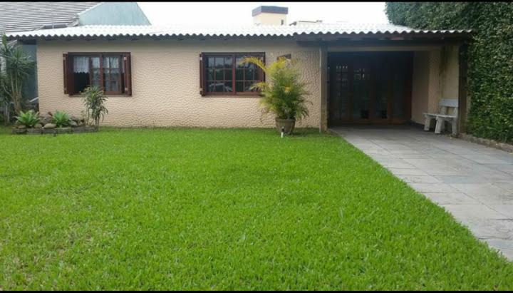 een huis met een groen gazon ervoor bij Casa Capao da Canoa in Capão da Canoa