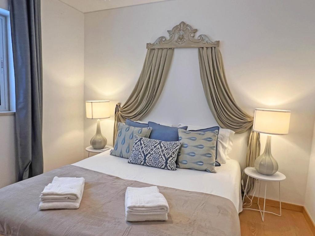 a bedroom with a large bed with blue pillows at APF Beach T2 Cabanas Home by Junto ao Mar in Cabanas de Tavira