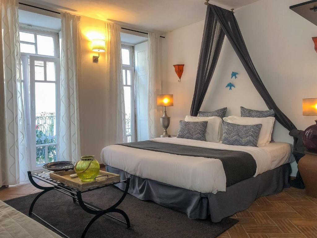 a bedroom with a large bed with a canopy at Stylish Studio Gilao in Taviras Historical Centre in Tavira