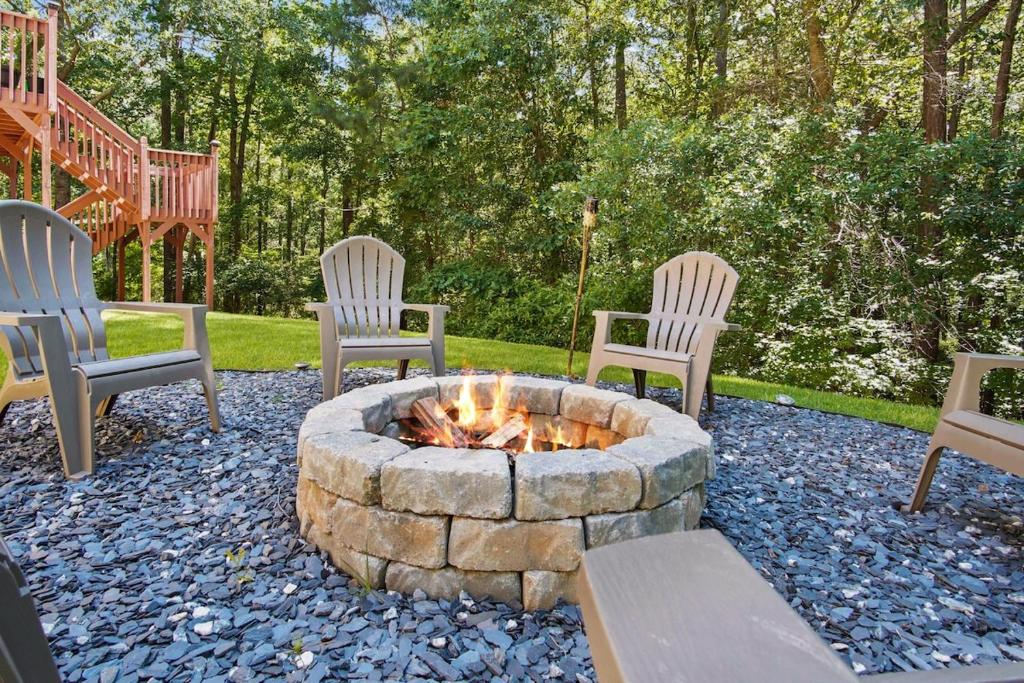 four chairs sitting around a fire pit in a yard at Great Family Home Near Stone Mountain Pk Sleeps 10 in Conyers
