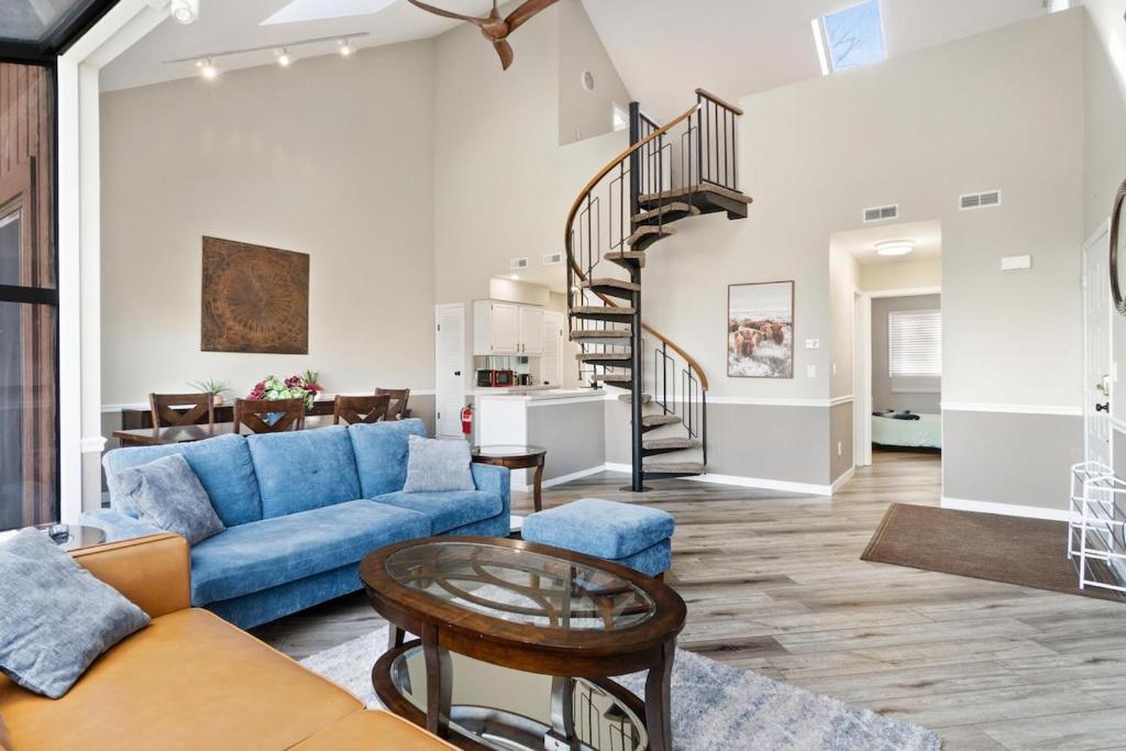 sala de estar con sofá azul y escalera de caracol en Mountain Creek Townhouse, en Vernon Township