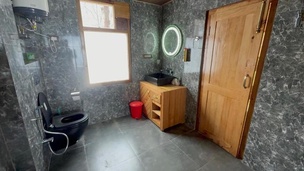 a bathroom with a shower and a toilet and a window at Hunting Wood Kathkuni Attic Cottage in Mandi