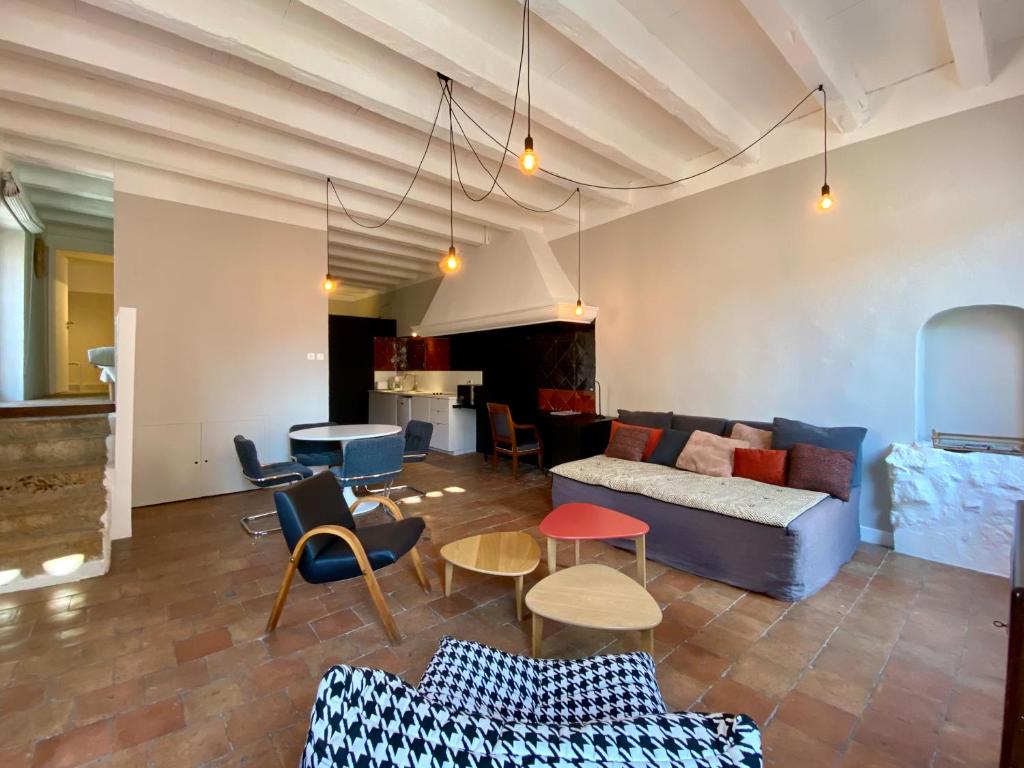 un salon avec un canapé, des tables et des chaises dans l'établissement Appartement Atypique Vieux-Port, à Marseille