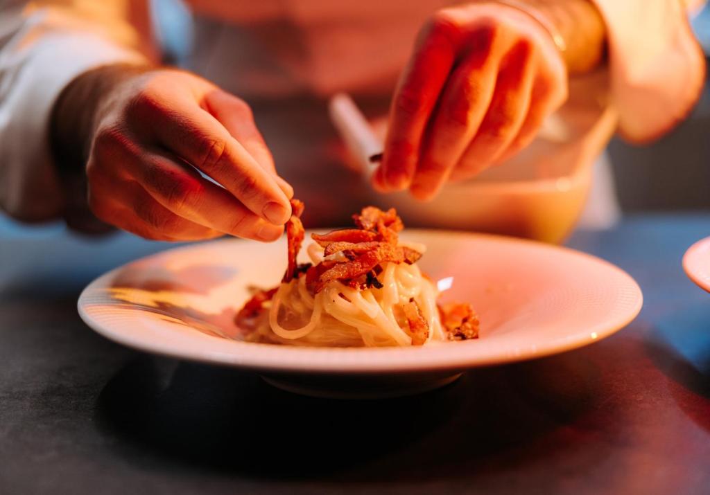 a person is eating food on a plate at Valtur Cervinia Cristallo Ski Resort in Breuil-Cervinia