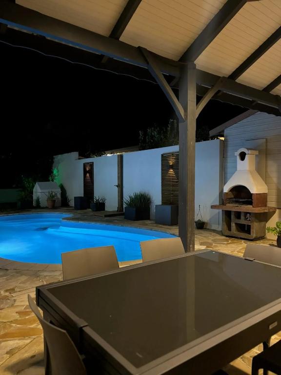 un patio con tavolo e sedie e una piscina di Villa spacieuse avec piscine à Saint-Pierre a Saint-Pierre