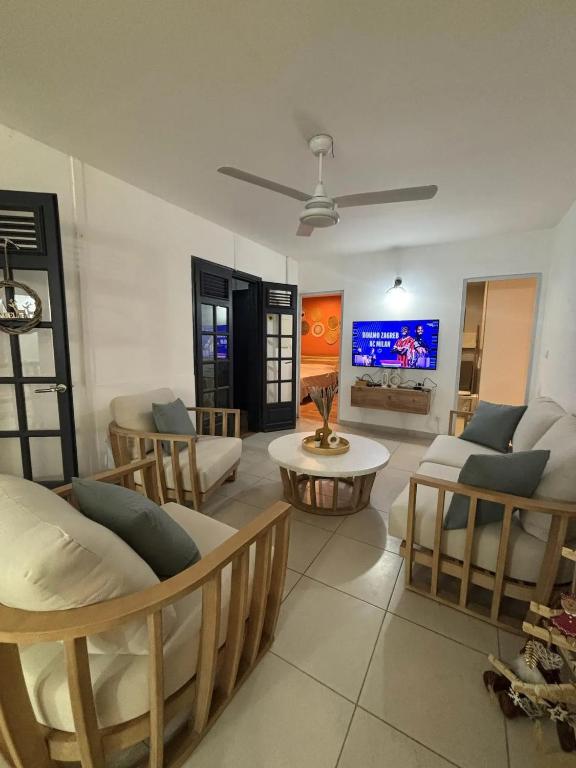 un soggiorno con divani e TV di Villa spacieuse avec piscine à Saint-Pierre a Saint-Pierre
