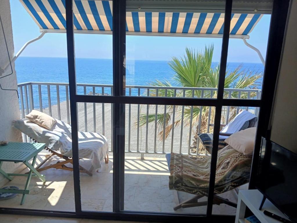 a room with a view of the ocean from a balcony at La Traiña in Adra