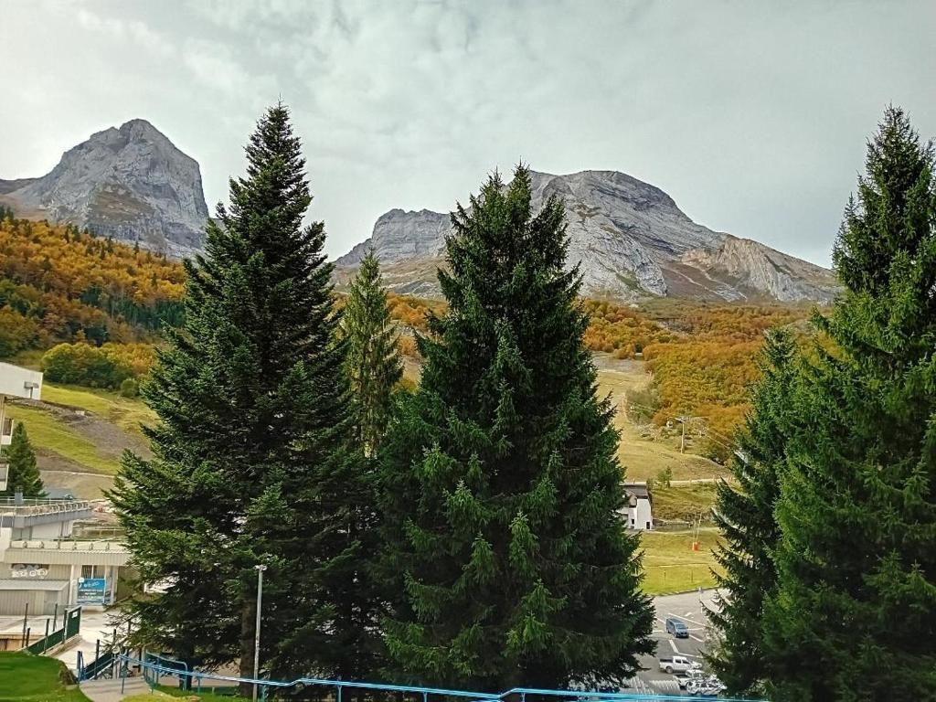 a group of pine trees with mountains in the background at A la montagne in Eaux-Bonnes