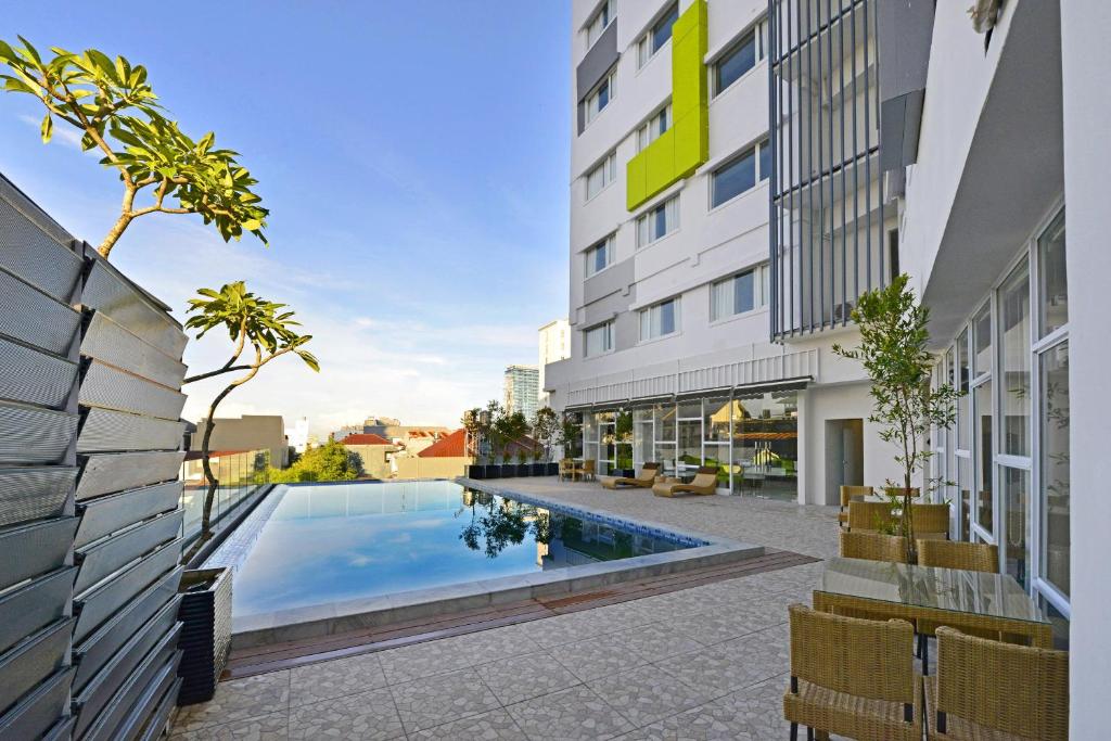 a swimming pool in the middle of a building at Whiz Prime Hotel Hasanuddin Makassar in Makassar