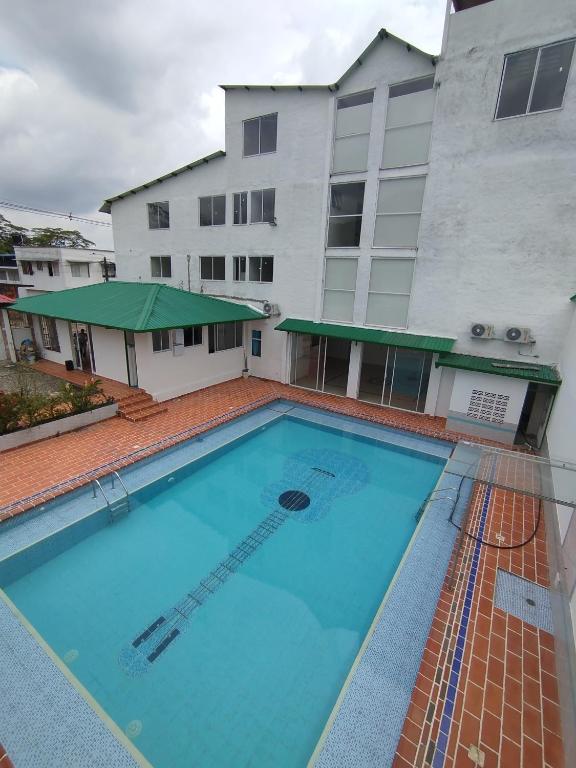 a large swimming pool in front of a building at Hotel Camino al Llano in Villavicencio