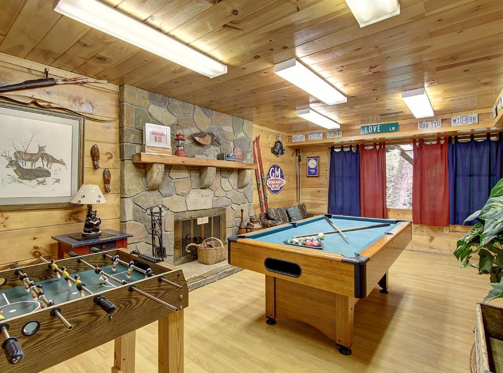 una sala de juegos con mesa de billar y chimenea en Game room, hot tub, flat easy drive to 3BR cabin!, en Sevierville