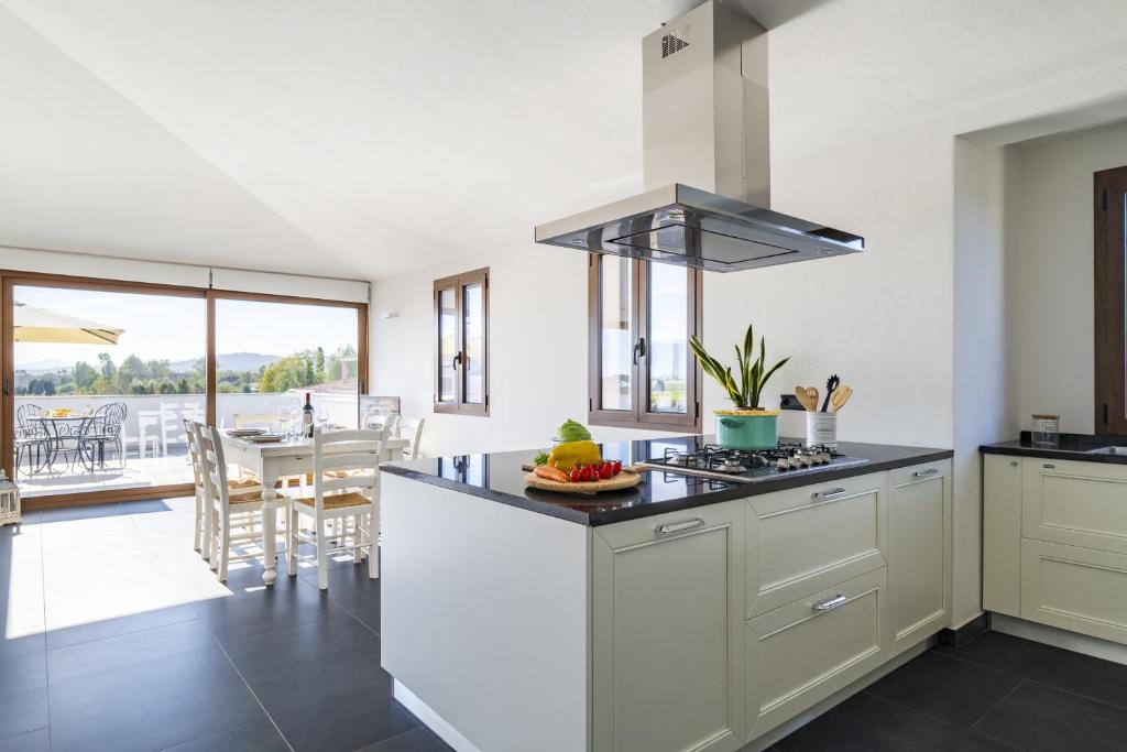 a kitchen with a view of a dining room at Lighthouse Holiday Home in Àrbatax