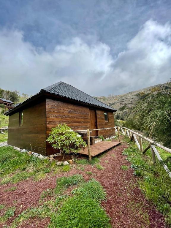 une cabane en bois avec un banc à côté d'une clôture dans l'établissement Mountain Eco Shelter 2, à Funchal