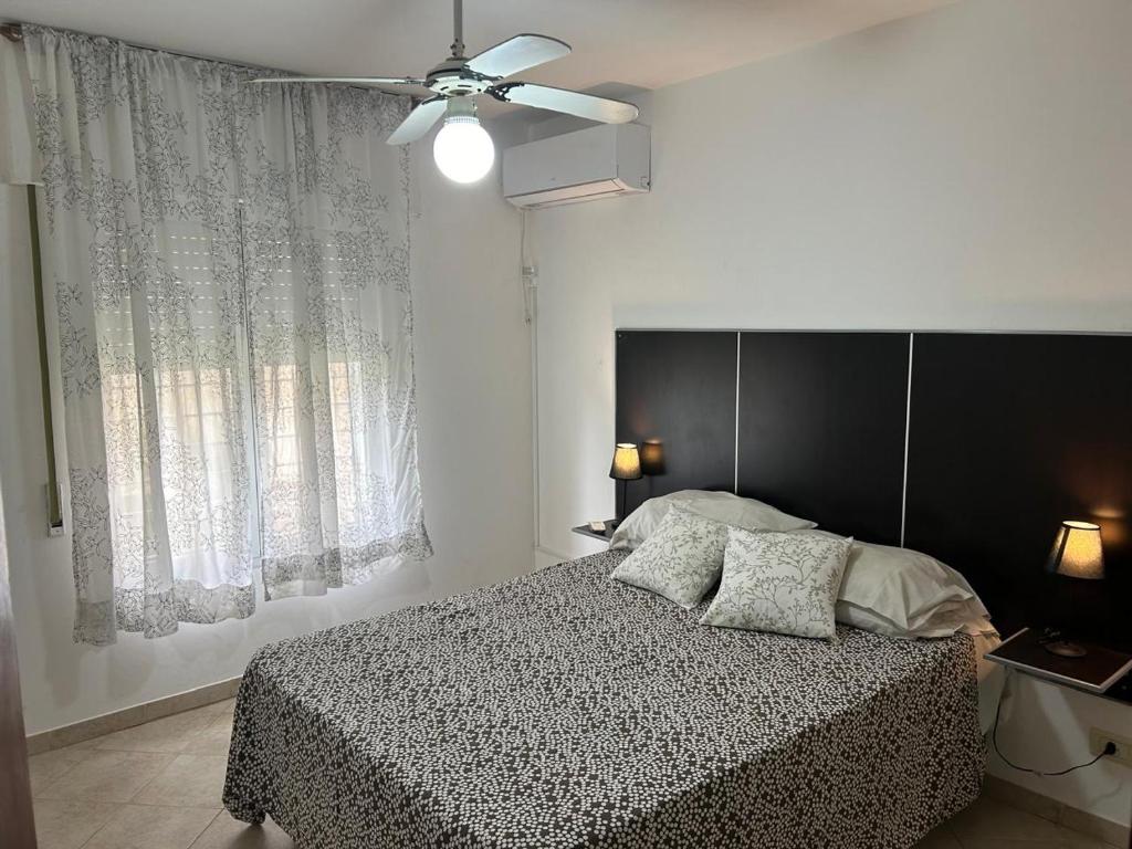 a bedroom with a bed and a ceiling fan at Amplia Casa - Vista Verde in Villa María