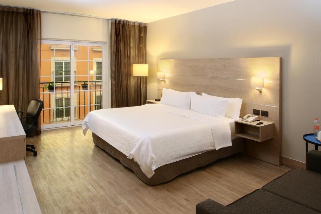 a hotel room with a large bed and a window at Holiday Inn Express Torreon by IHG in Torreón