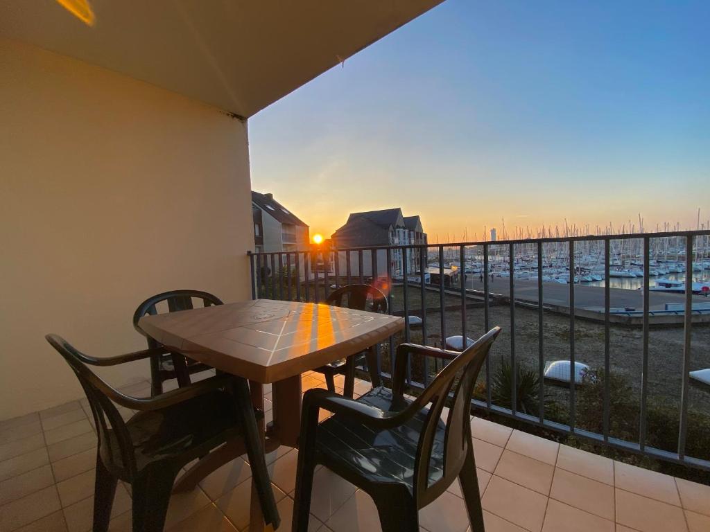 une table et des chaises sur un balcon avec vue dans l'établissement Ref 137 Appartement pour 2 vue port du Crouesty ARZON, à Arzon
