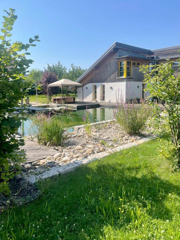 a house with a pond in front of a house at Gut Müllerleile Ferienhaus in Gengenbach