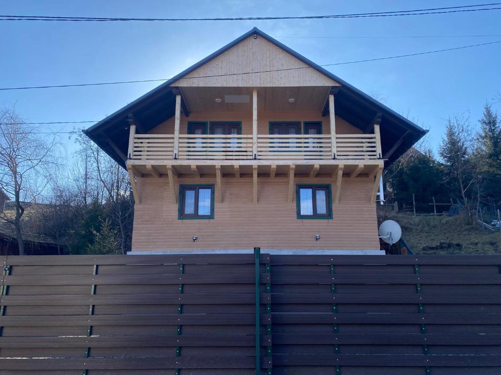 a large wooden house behind a wooden fence at Skh 3 in Praid