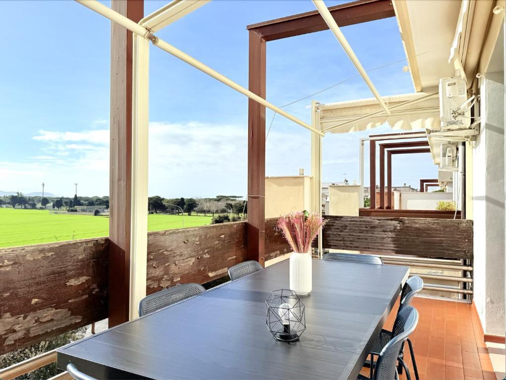 een eetkamer met een tafel en een groot raam bij Appartamento Spiga in San Vincenzo