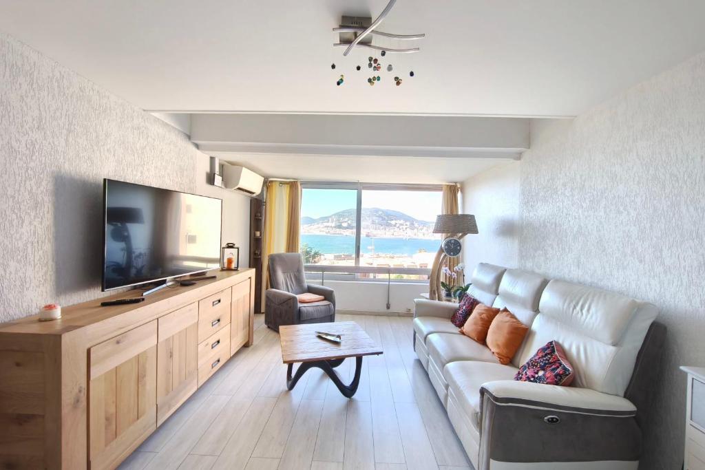 un salon avec un canapé et une télévision à écran plat dans l'établissement Bright apartment 3 minutes from the beach, à Ajaccio