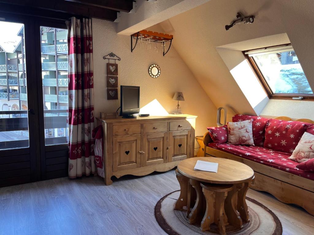 un salon avec un canapé et une table dans l'établissement Ski in-ski out appartement in het centrum van Oz 3300, à Oz