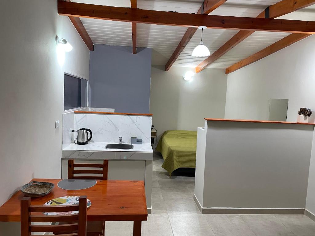 Una cocina con una mesa y una habitación con una cama. en Cacho's house, en Junín