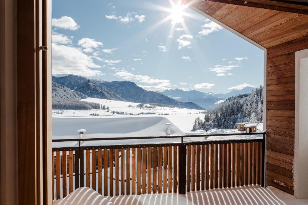 een balkon met uitzicht op een met sneeuw bedekte berg bij Silent Luxury Chalet LAIET in San Valentino alla Muta