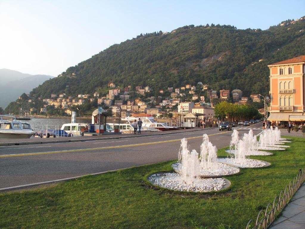 a row of water fountains on the side of a road at Como Luxury Rooms in Como