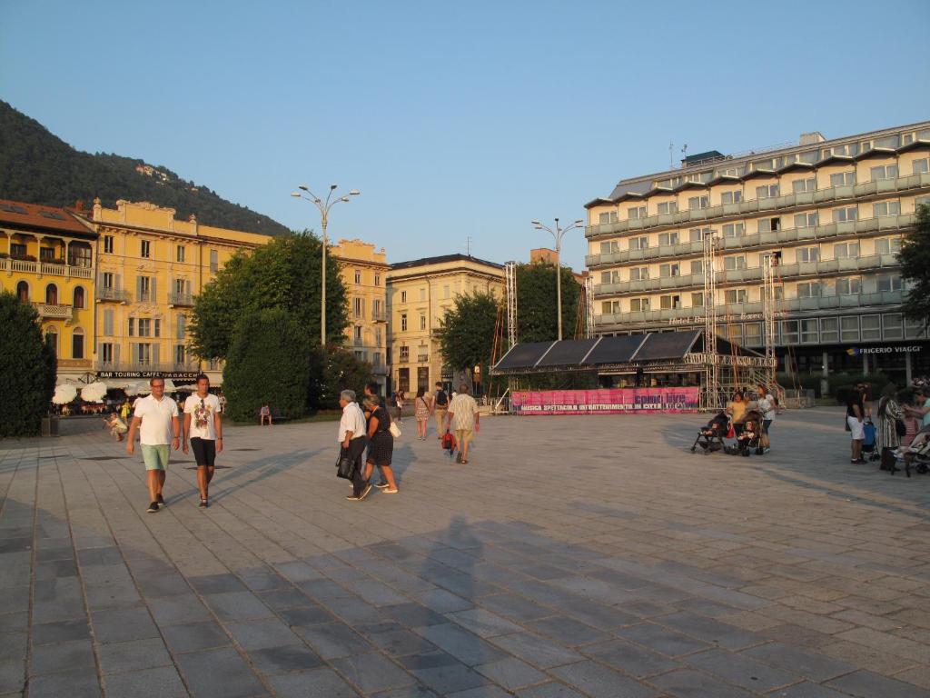 a group of people walking around a city square at Como Luxury Rooms in Como